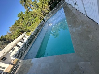 Modern pool deck with stone paving and turf landscaping
